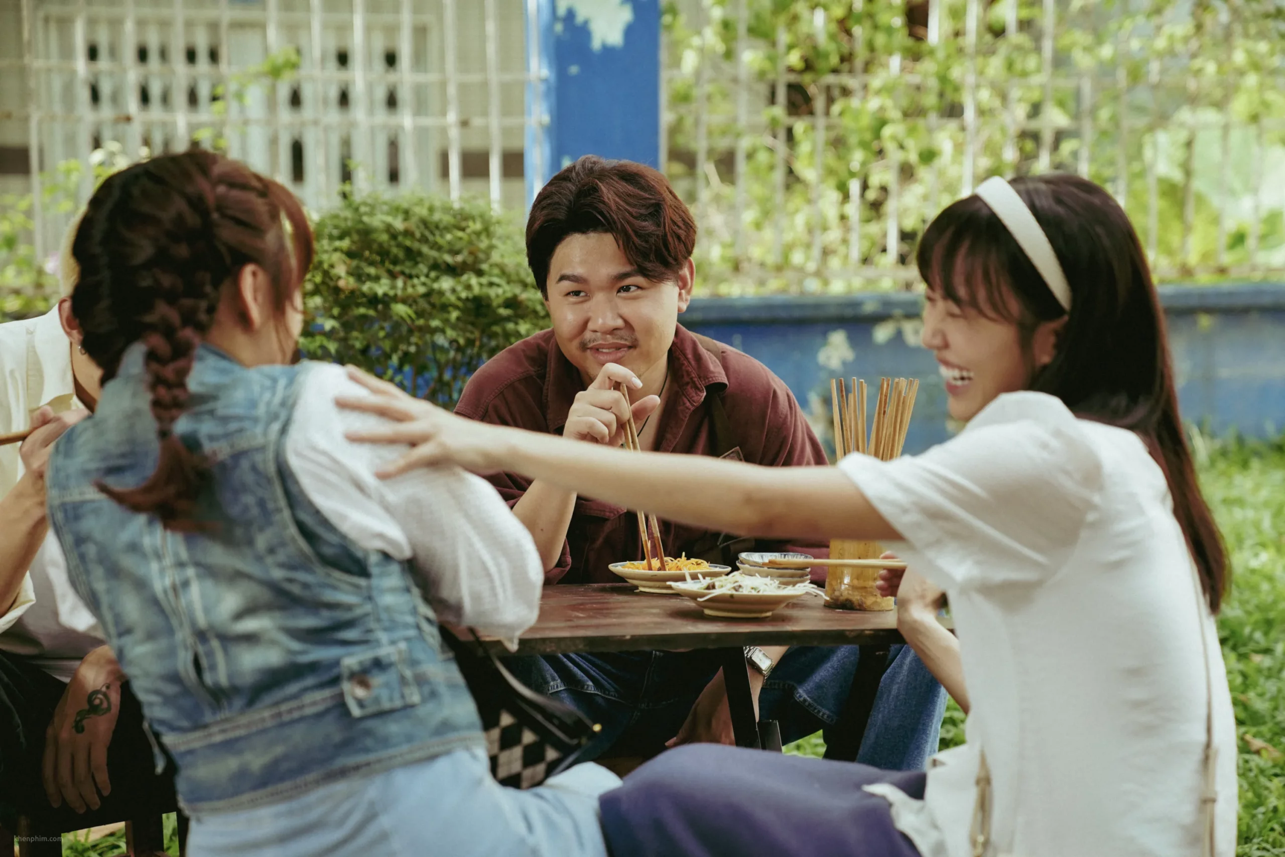 Quốc Khánh trong một cảnh cả nhóm ngồi ăn ở quán vỉa hè